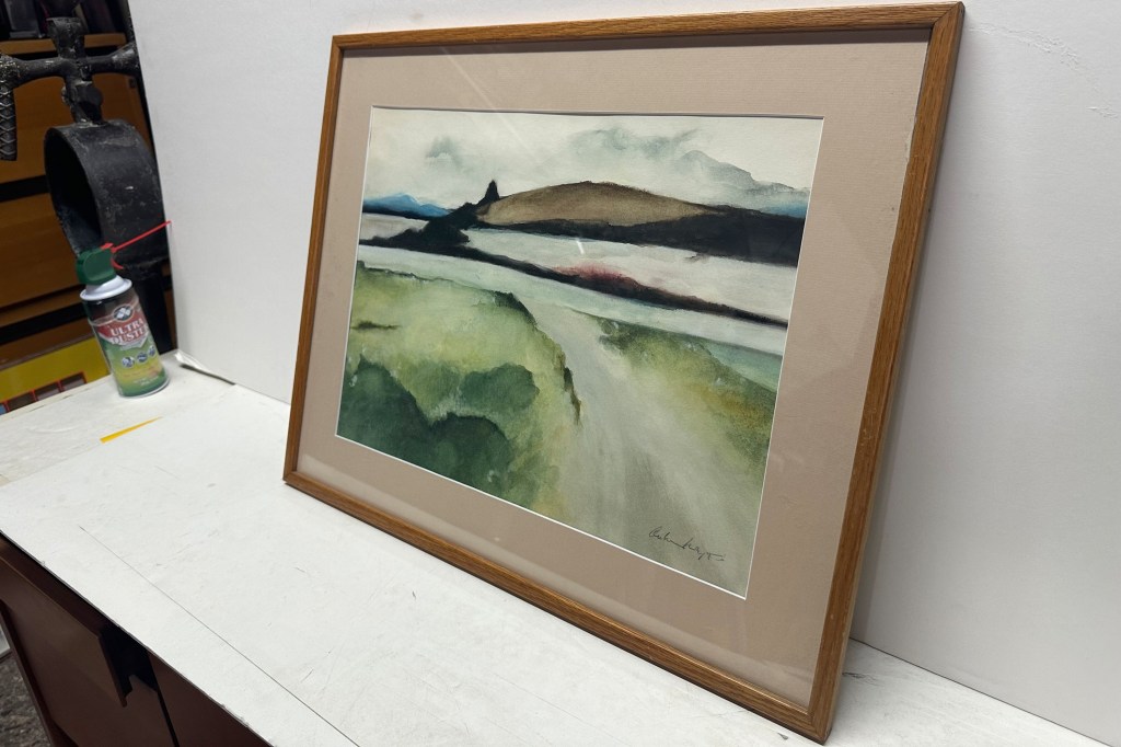 A framed forgery of an Andrew Wyeth painting, featuring a landscape of hills and green fields, is shown at RoGallery.