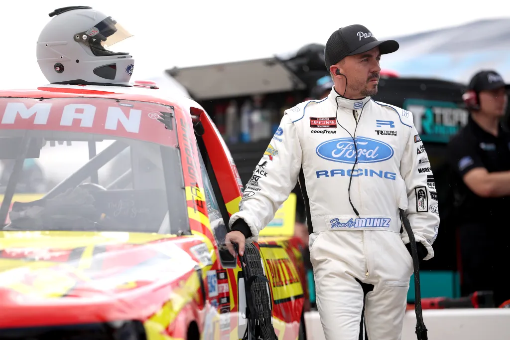 Frankie Muniz, in a white Ford racing suit, looks on during practice for the NASCAR Craftsman Truck Series Black's Tire 200.