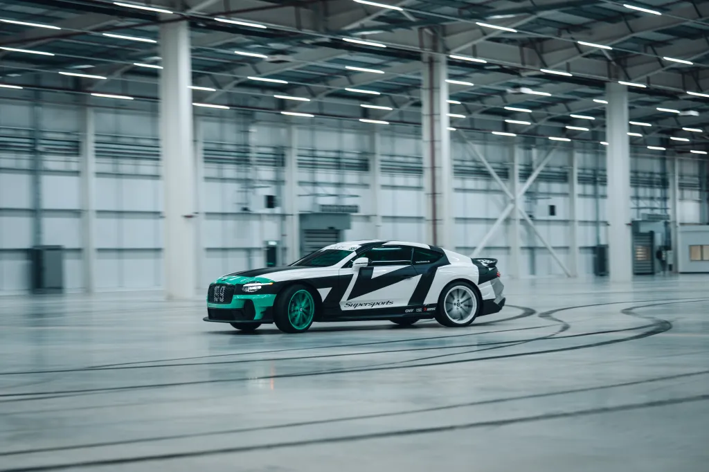 Bentley Supersports car, designed by Travis Pastrana, drifting in a large warehouse.