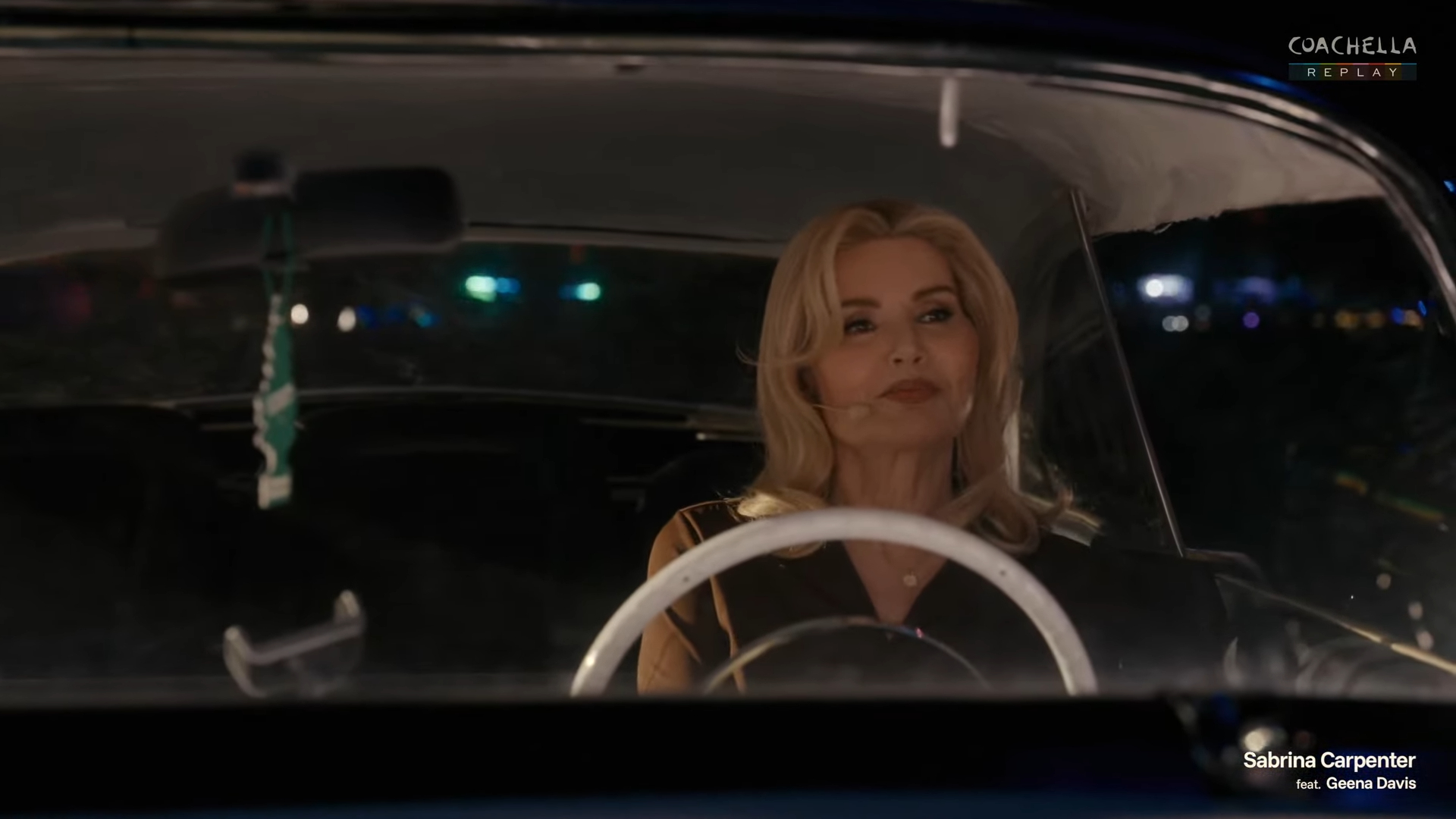 Geena Davis in a car at a drive-in movie theater.