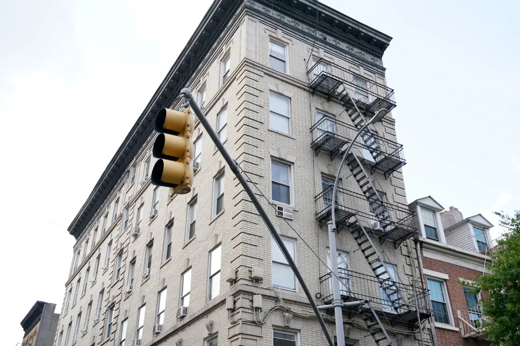 An apartment building in New York City with fire escapes on its facade.