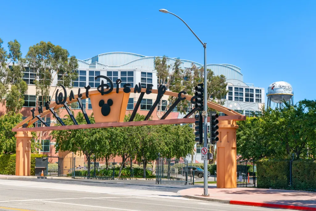 The Walt Disney Company corporate headquarters in Burbank, California, showing the entrance archway with Mickey Mouse, a street light, and the Walt Disney Company water tower.