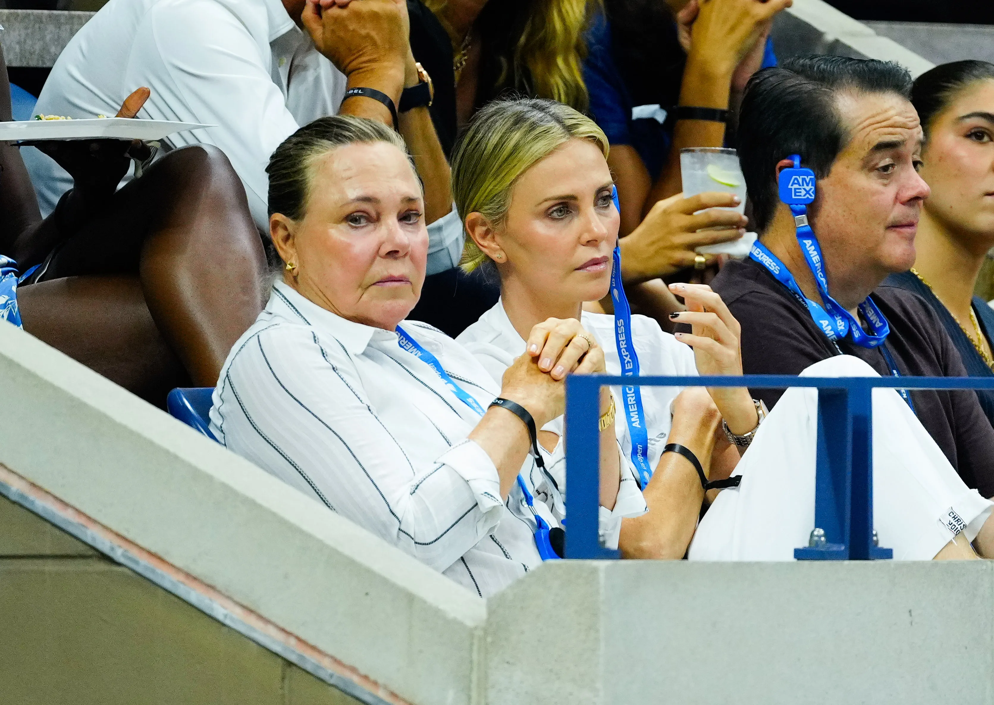 Gerda Jacoba Aletta Maritz and Charlize Theron sitting in the stands at the US Open.