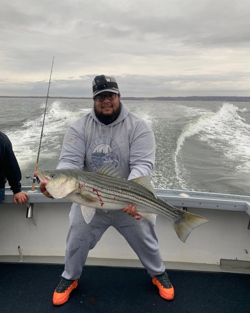 gilberto diaz holding a fish on a boat