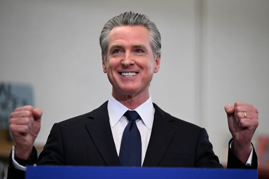 Gavin Newsom, California Governor, smiling with both fists raised.