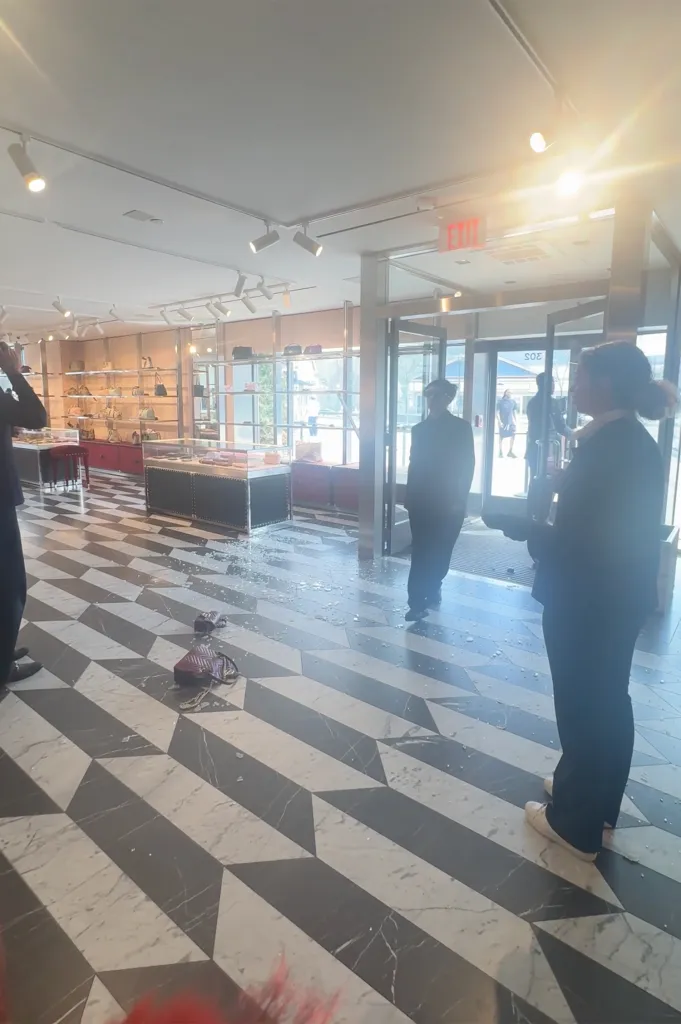 Gucci store after a smash and grab, with shattered glass on the floor.