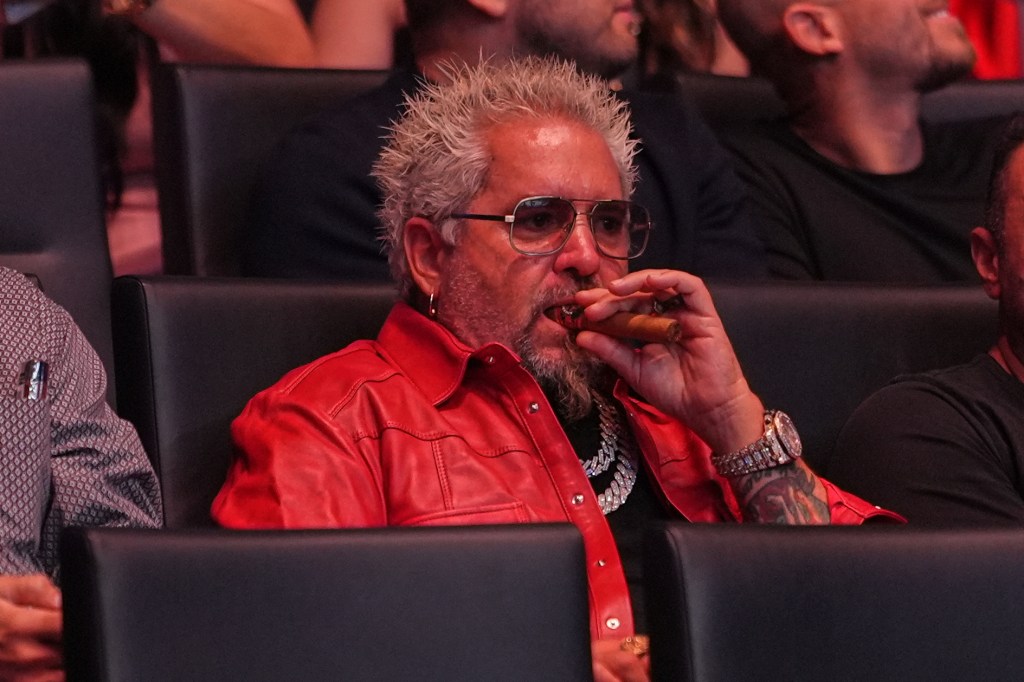 Guy Fieri smoking a cigar at UFC 327.