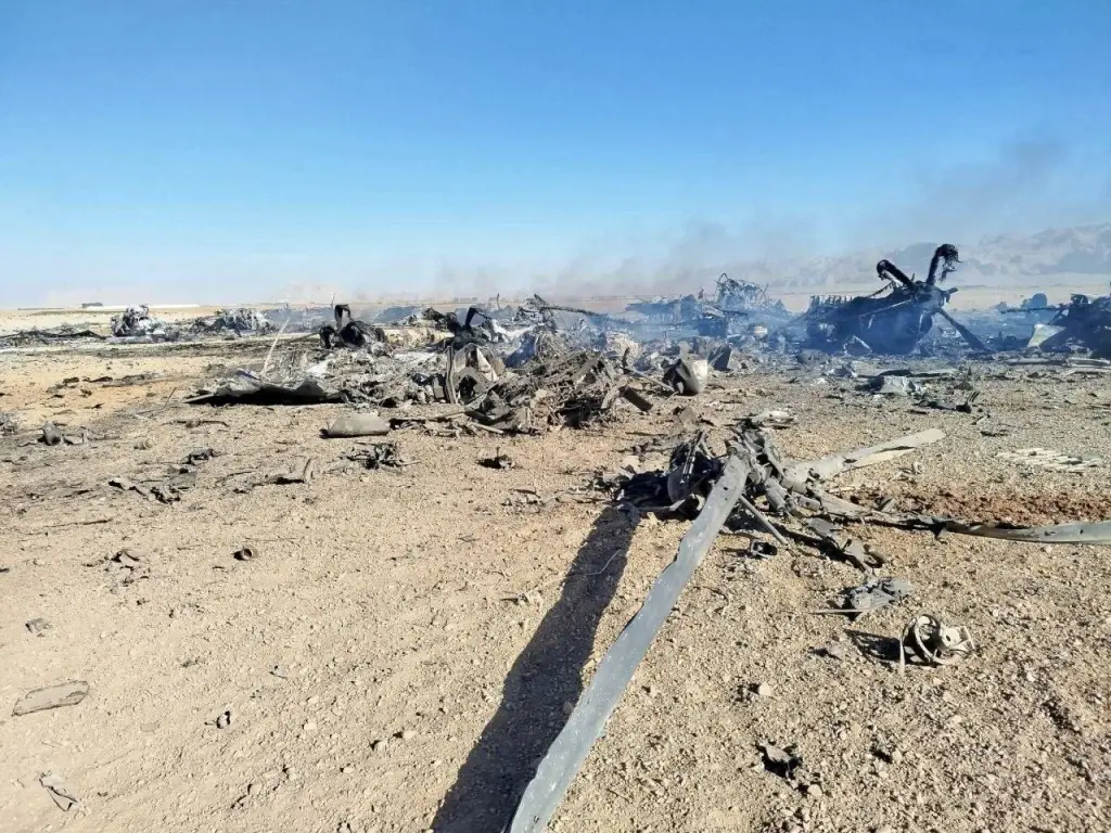 Wreckage of a downed US military aircraft in a desert landscape.