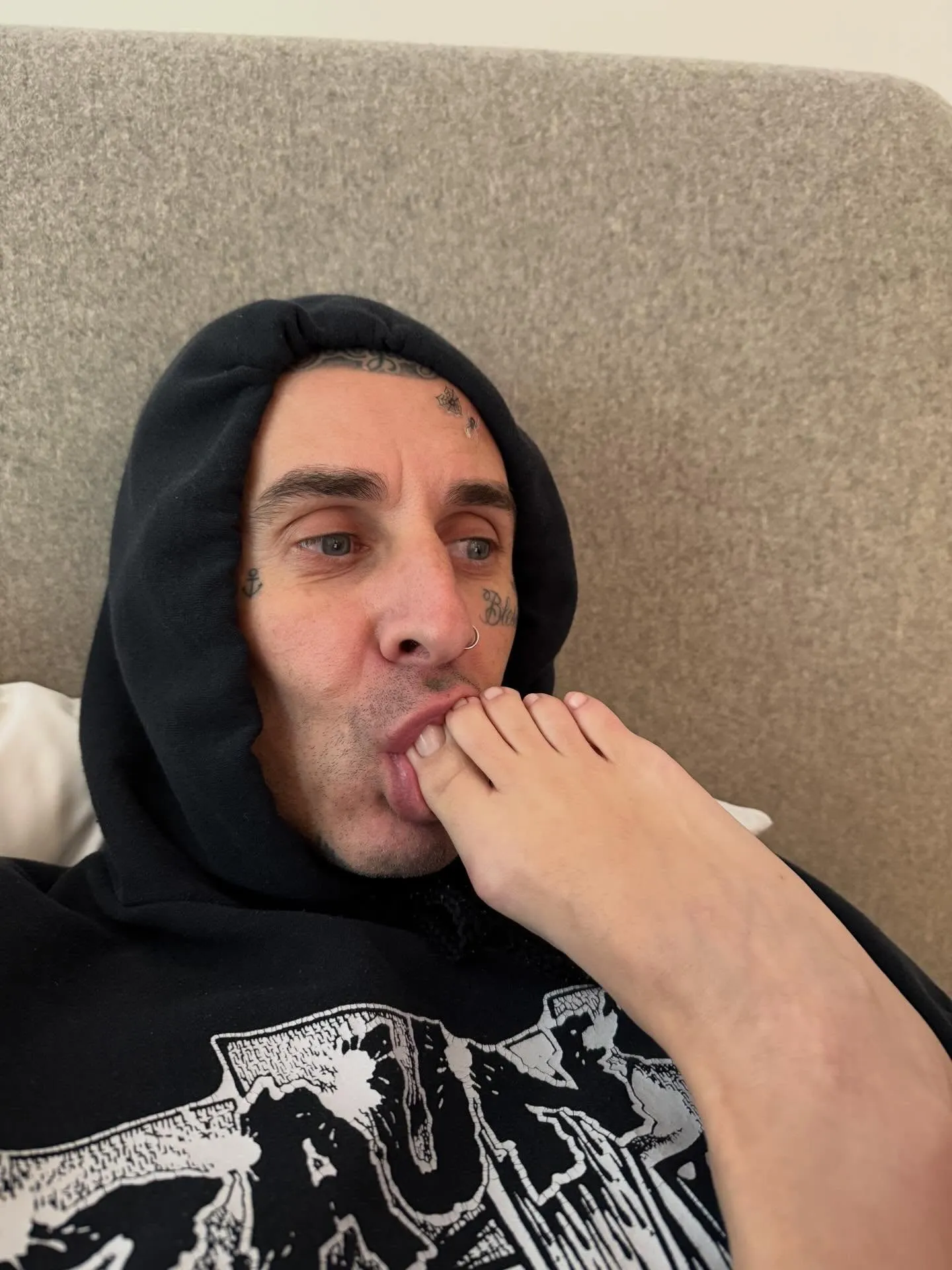 Travis Barker with his wife Kourtney Kardashian's foot in his mouth.