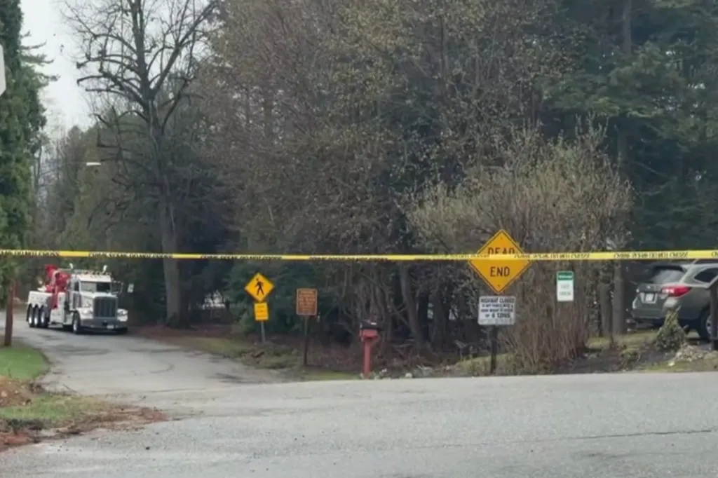 A tow truck on a road blocked by yellow caution tape.
