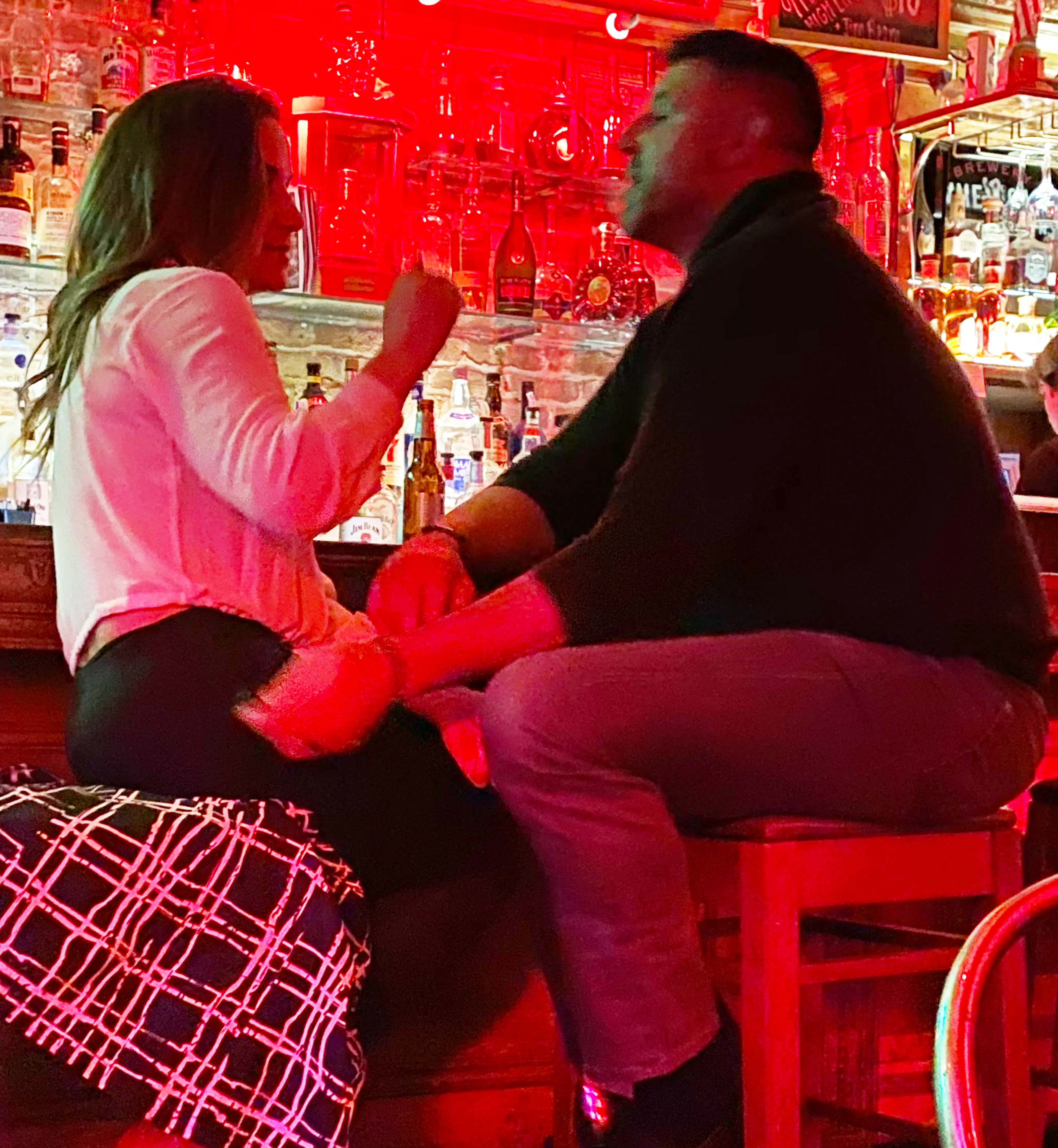 Mike Vrabel and Dianna Russini kissing and chatting at a bar.