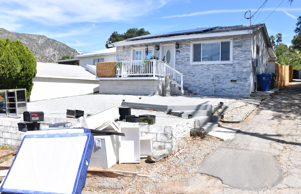 Home of Hamideh Soleimani Afshar in Tujunga, California, with mattresses and other discarded items in the foreground.