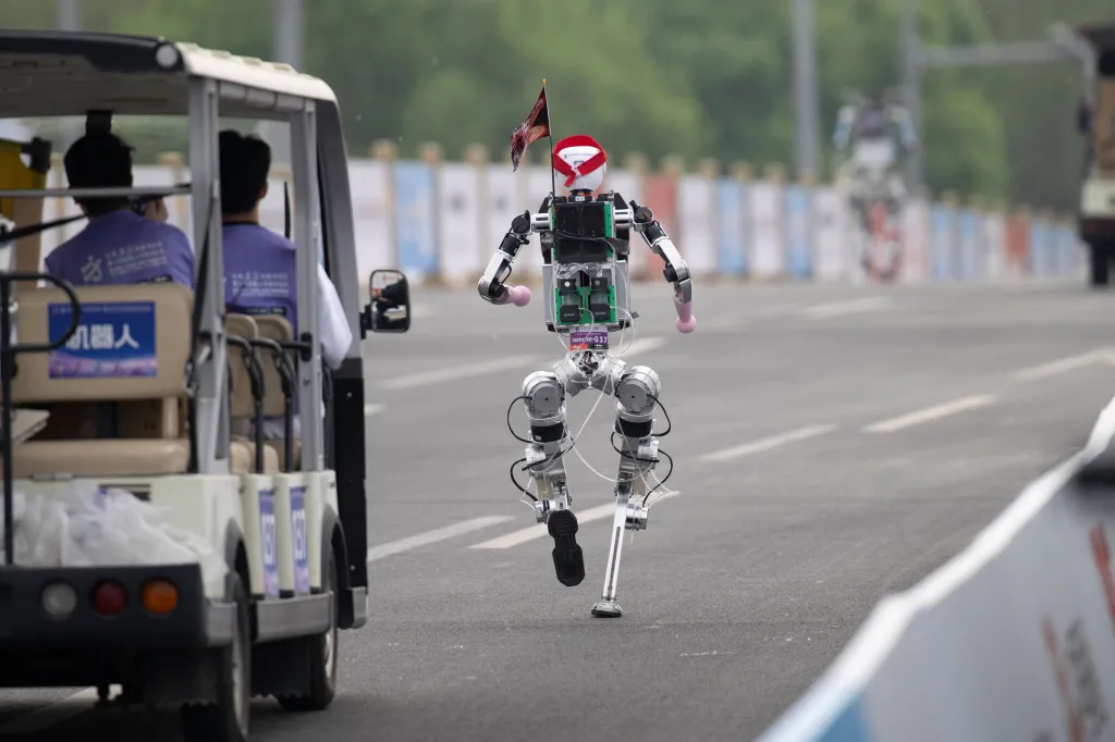 A humanoid robot runs on a road during a half marathon race.