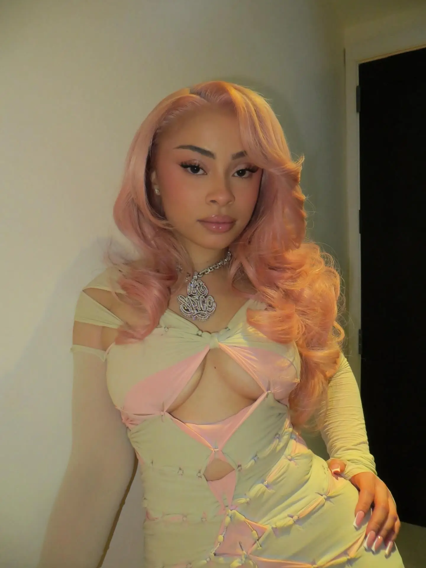 Ice Spice in a cutout dress with pink hair and a diamond necklace.