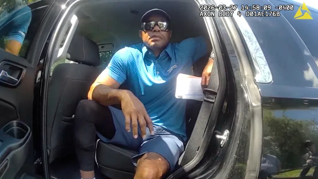 Tiger Woods sitting in the back of an unmarked police vehicle.