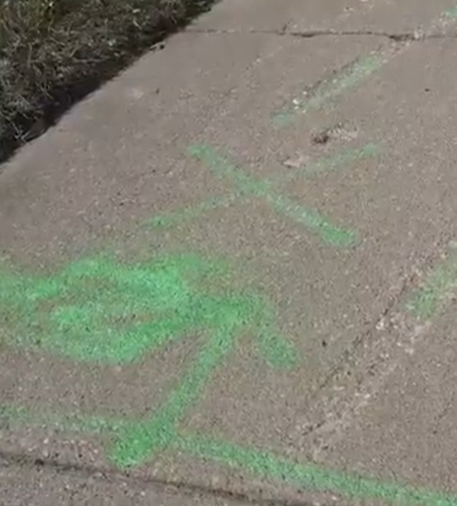 Green spray paint markings on concrete.