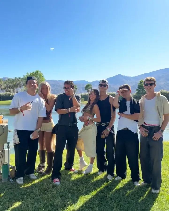 A group of influencers wearing festival wristbands pose outdoors.