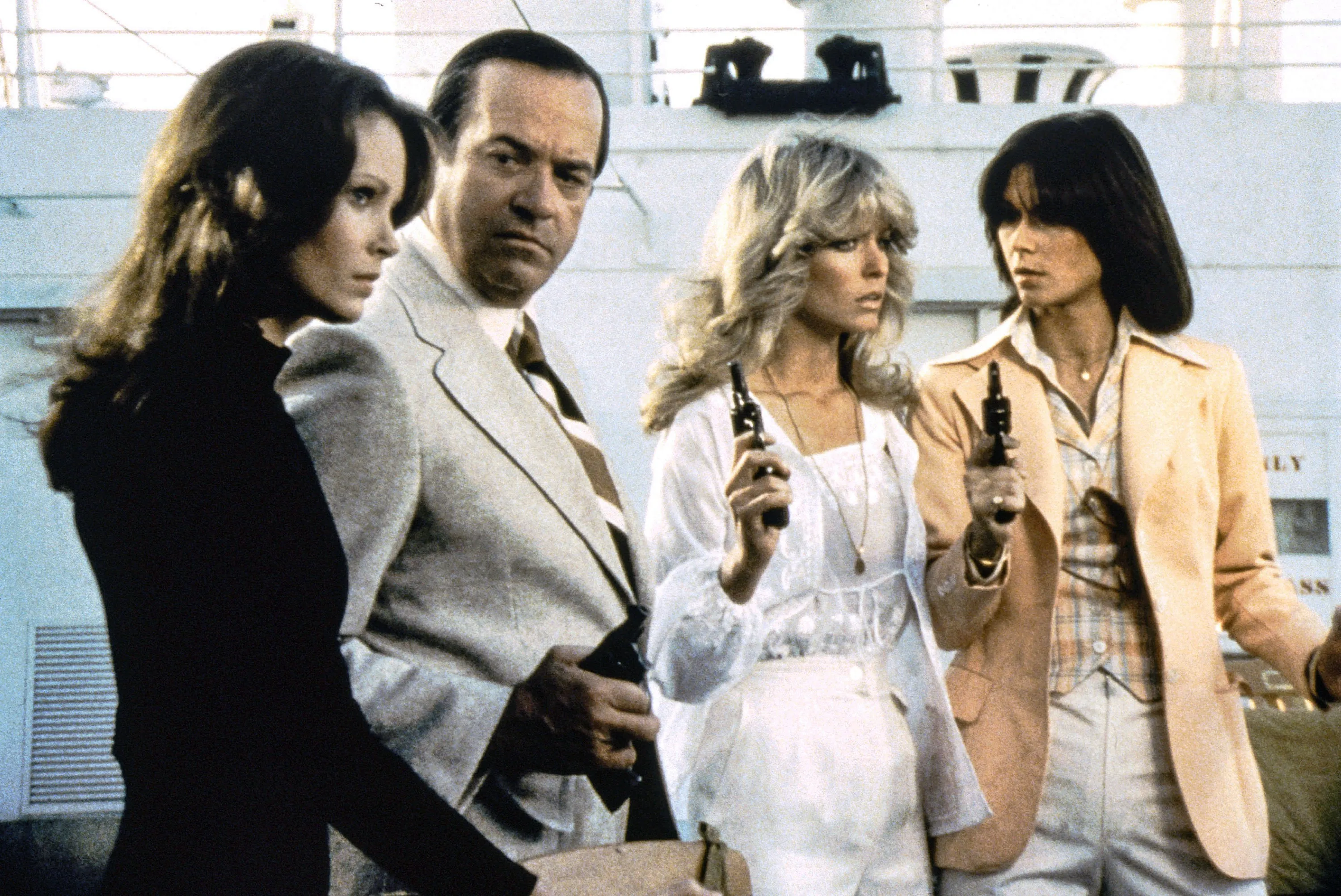 Jaclyn Smith, David Doyle, Farrah Fawcett, and Kate Jackson from Charlie's Angels, holding guns.