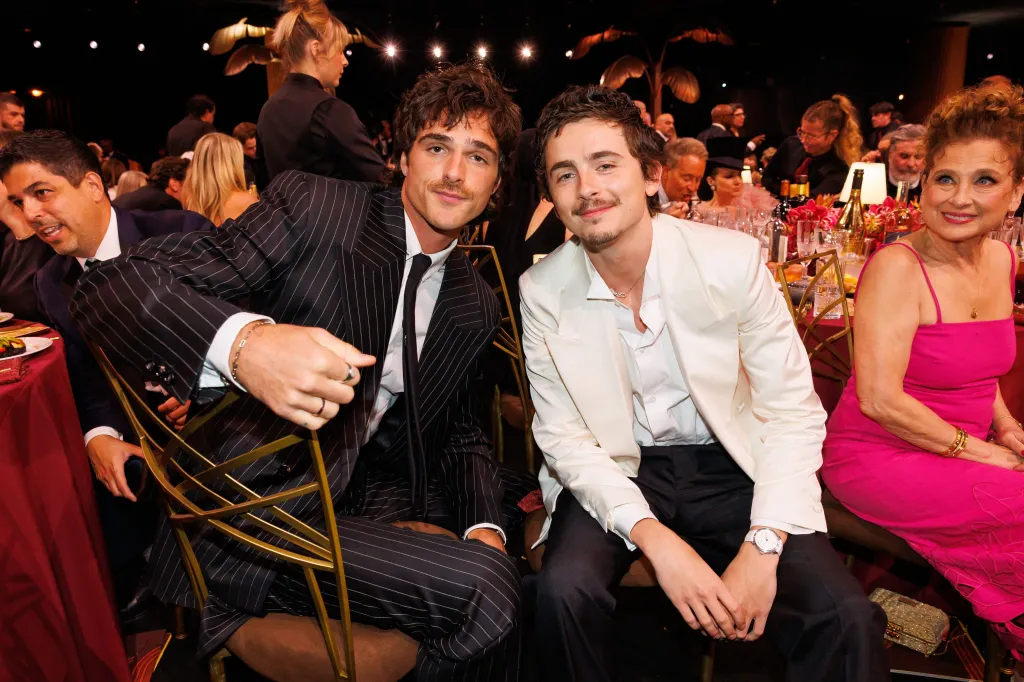 Jacob Elordi and Timothée Chalamet sitting at a table with other guests at the 32nd Annual Actor Awards.