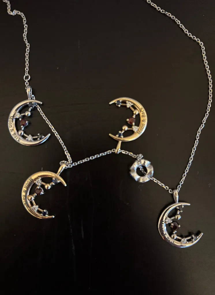 A pendant necklace with moonstone charms and birthstones