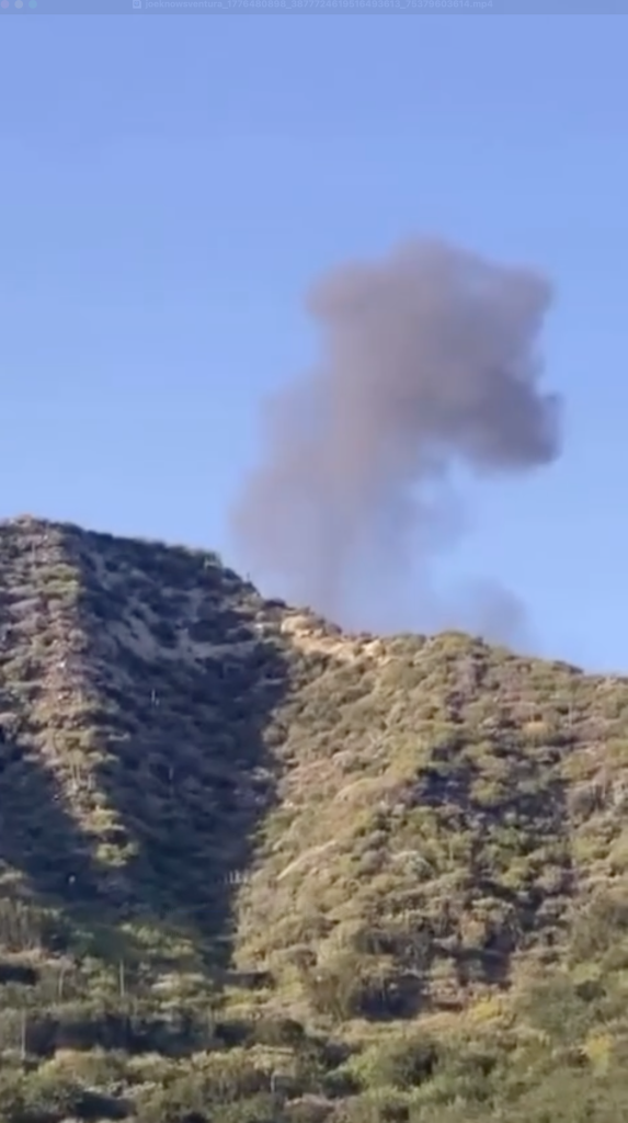 Smoke rising behind a mountainous area in California.