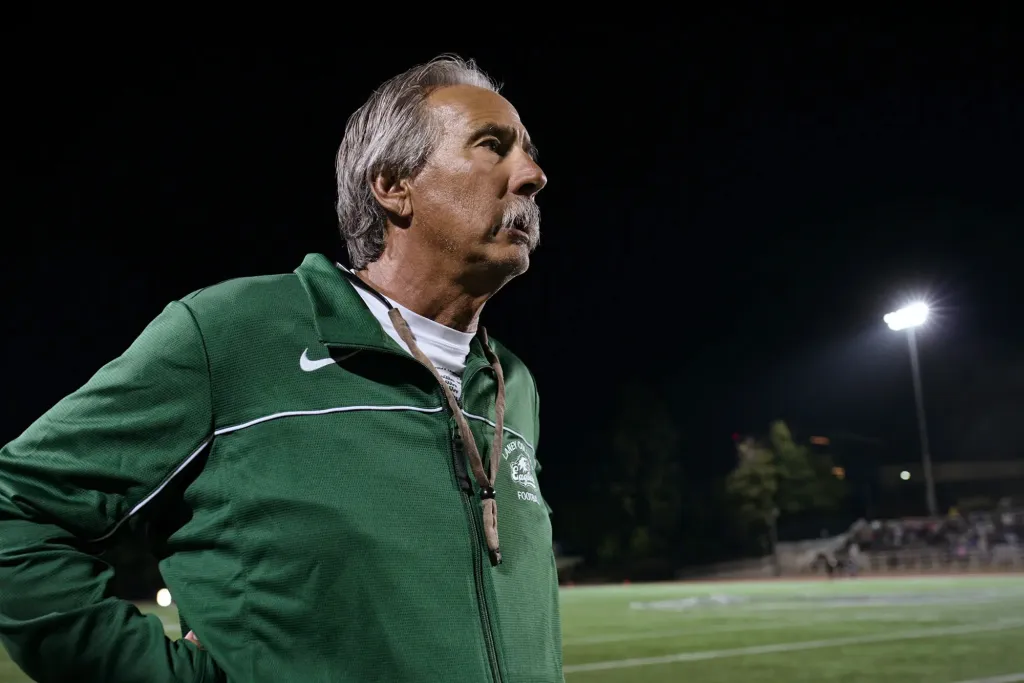 John Beam, athletic director and former football coach, on a football field at night.