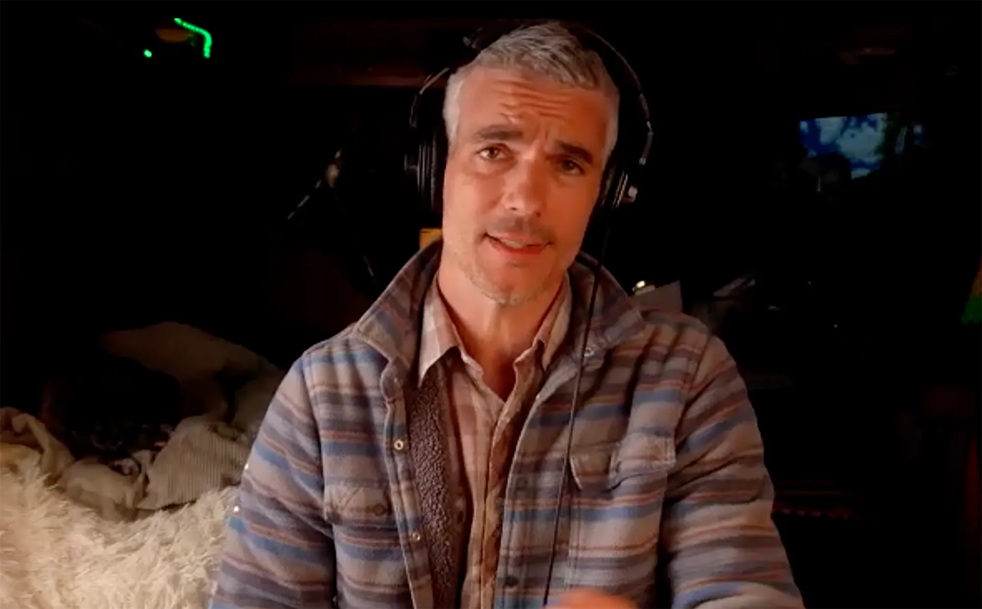 Josh Kloss in a plaid jacket and headphones.