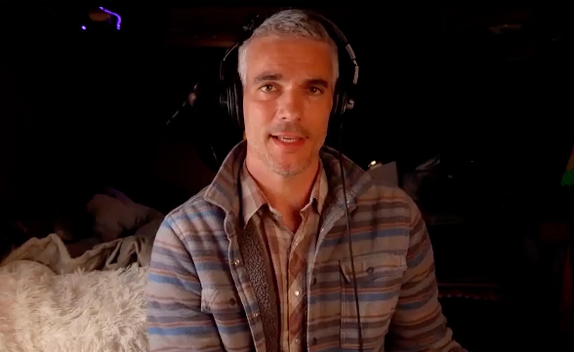 Josh Kloss wearing headphones and a striped shirt.