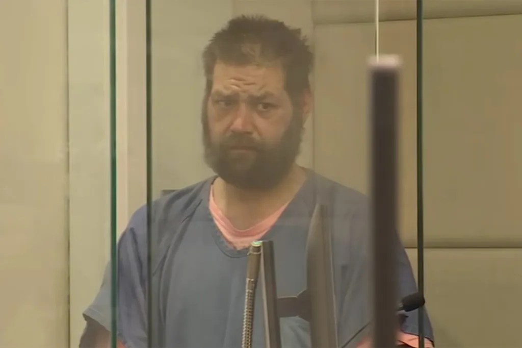 Judson Curtis DeFir, a man with a beard and messy hair, looks straight ahead in court.