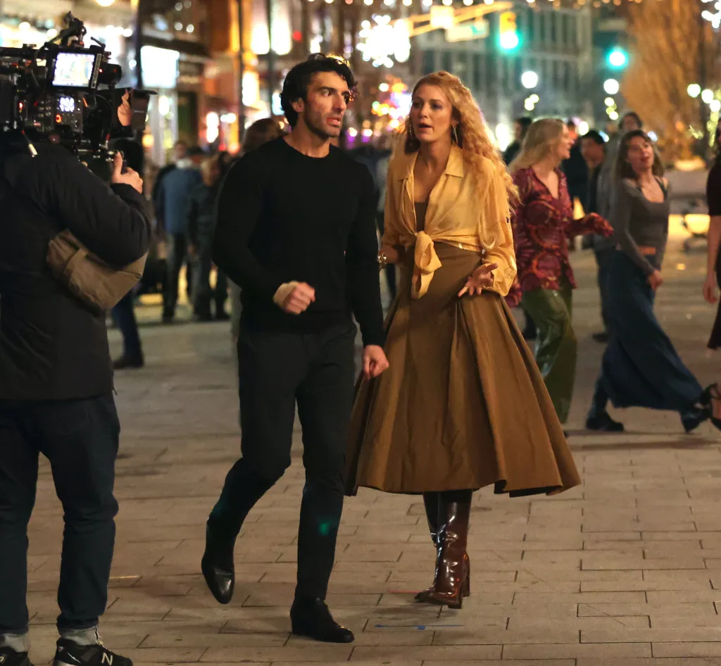 Justin Baldoni and Blake Lively walking past a camera on the set of 'It Ends with Us.'