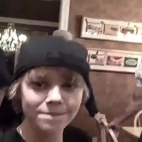 Justin Bieber as a young boy wearing a backwards cap.