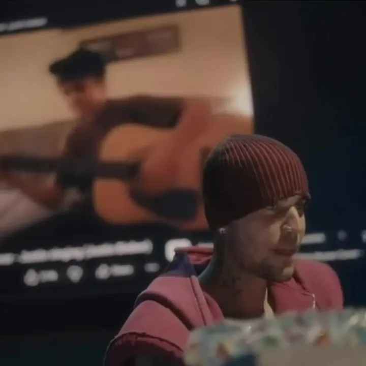 Justin Timberlake watching a video of Justin Bieber playing guitar.