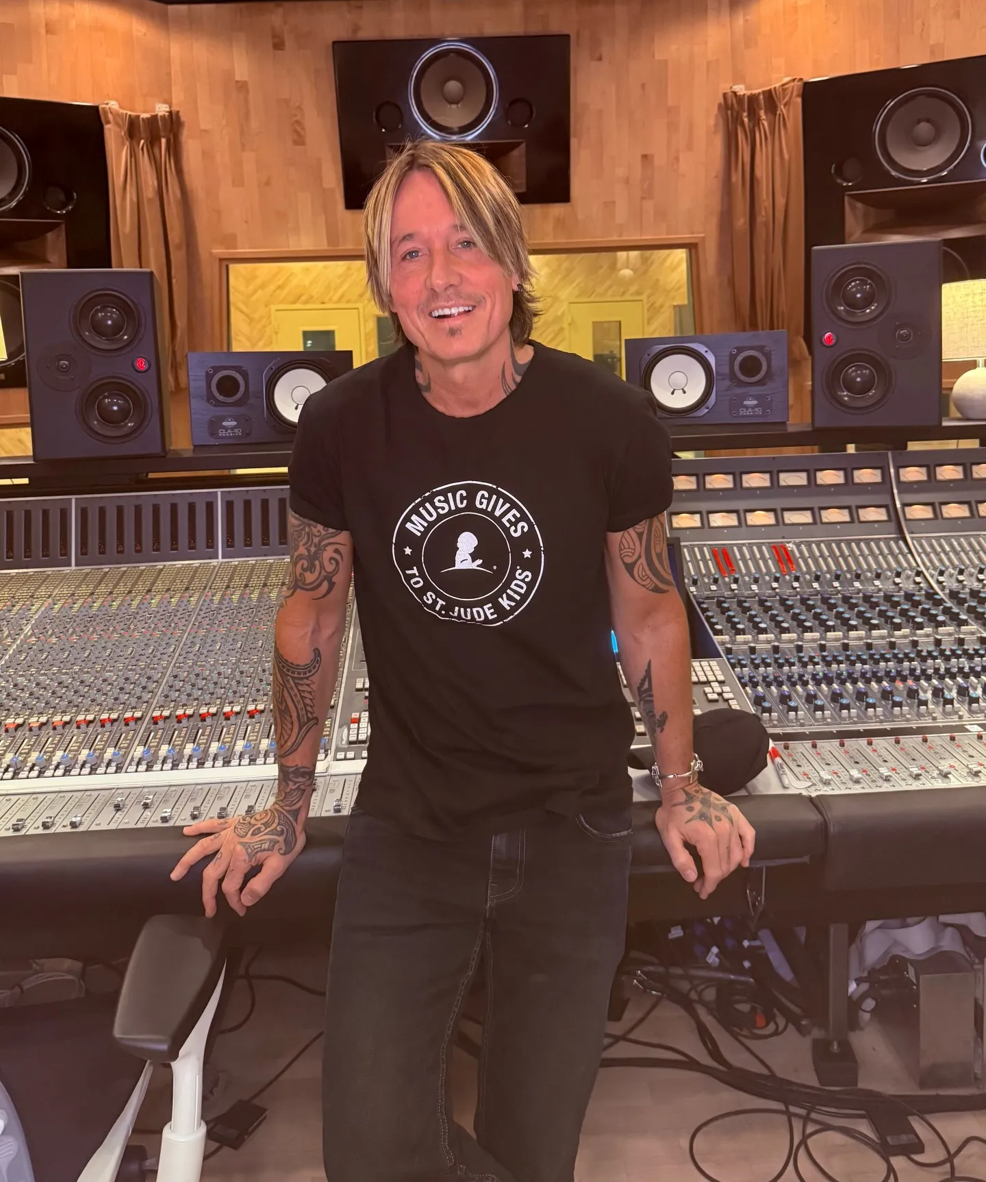 Keith Urban smiling in a recording studio, wearing a 