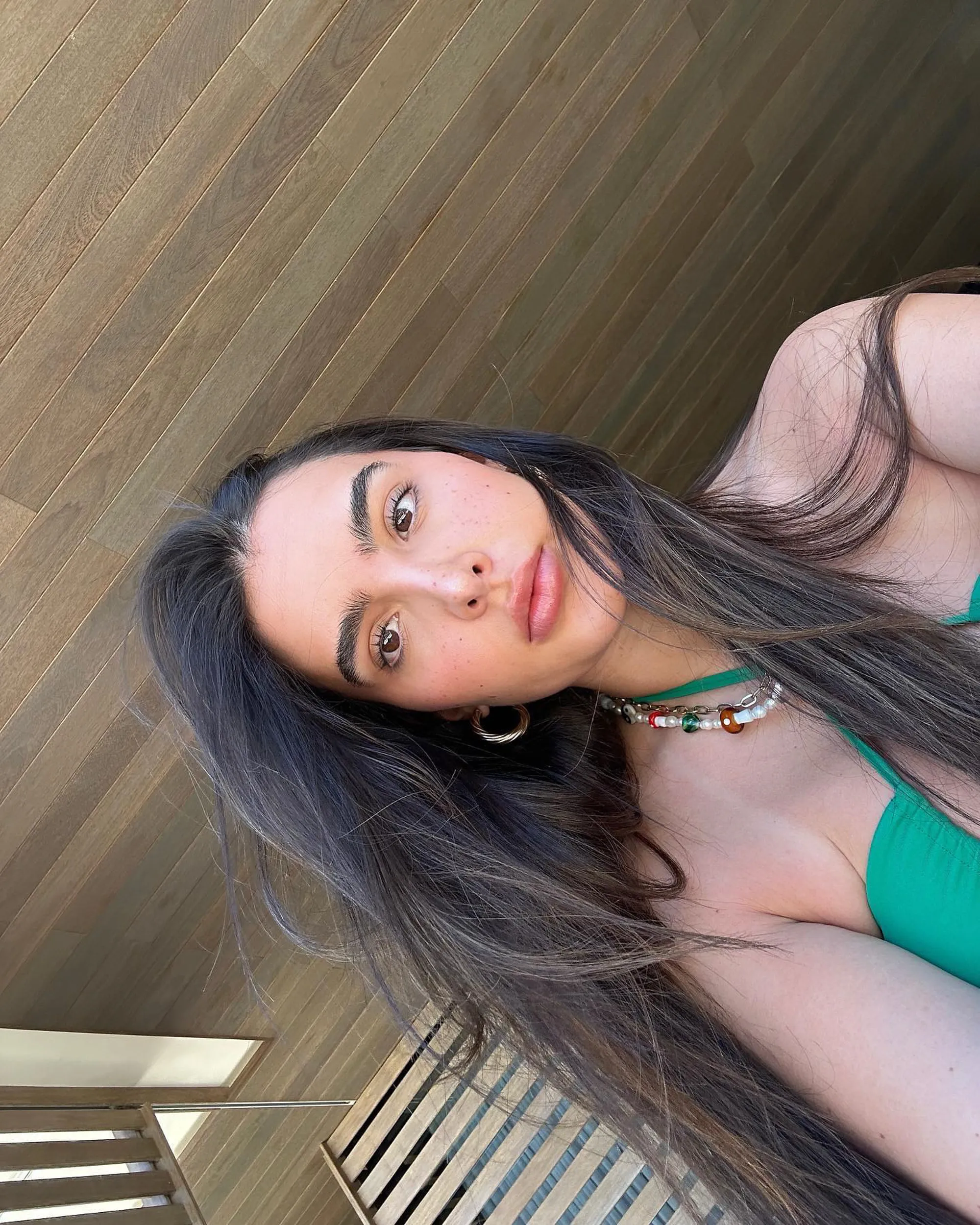 A selfie of Sophia Umansky looking at the camera, wearing a green top and a necklace.
