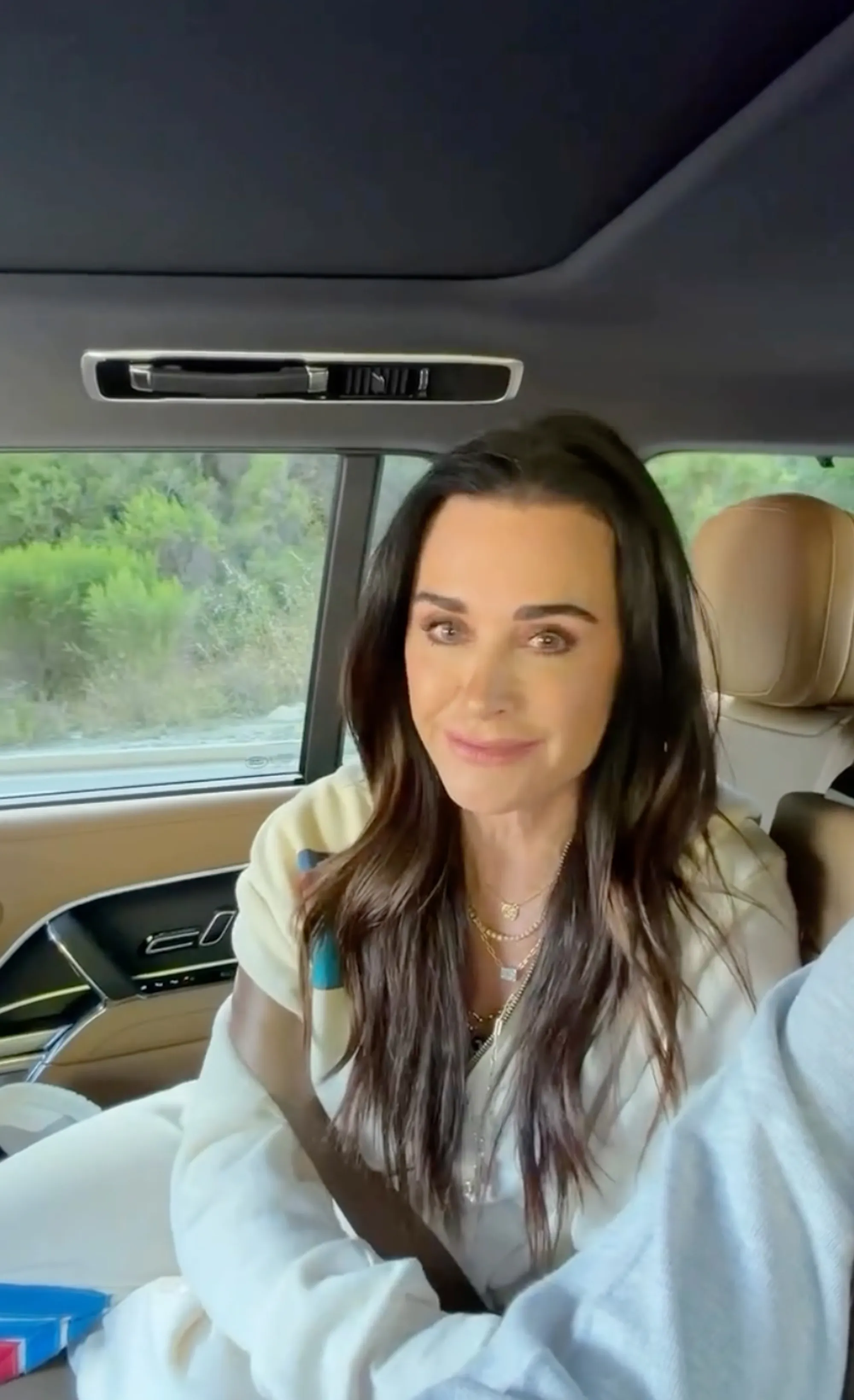 Kyle Richards in a car, smiling.