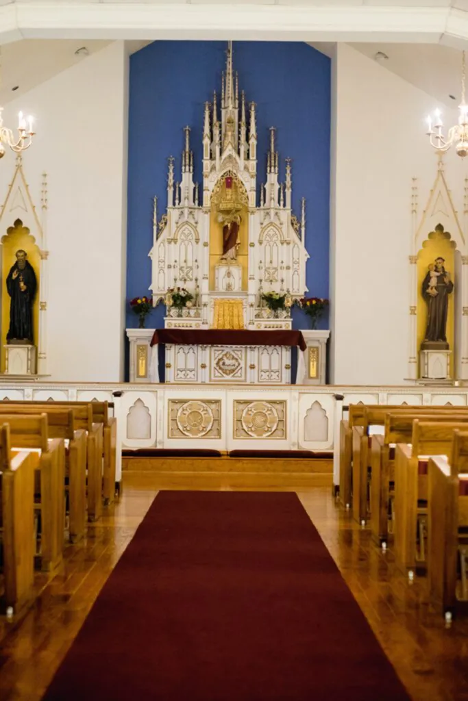 Interior of Our Lady of Fatima Roman Catholic Church, with a red carpet leading to the altar.
