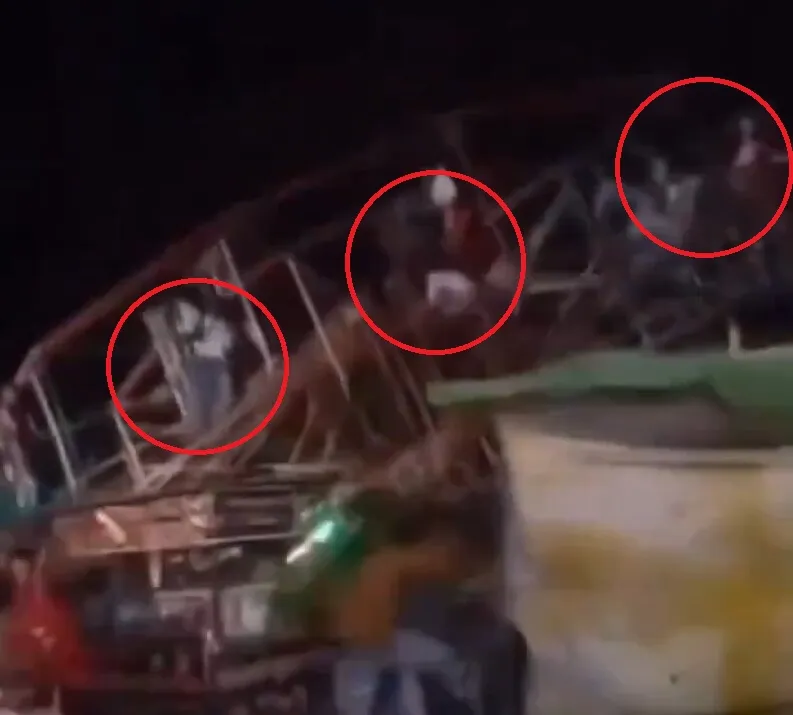 Video grab of an overloaded Ferris wheel collapsing, with people highlighted in red circles.