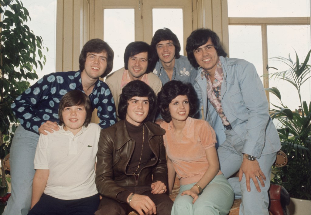 The Osmonds family, with Jimmy, Donny, and Marie in the front row, and Alan, Wayne, Merrill, and Jay behind them.