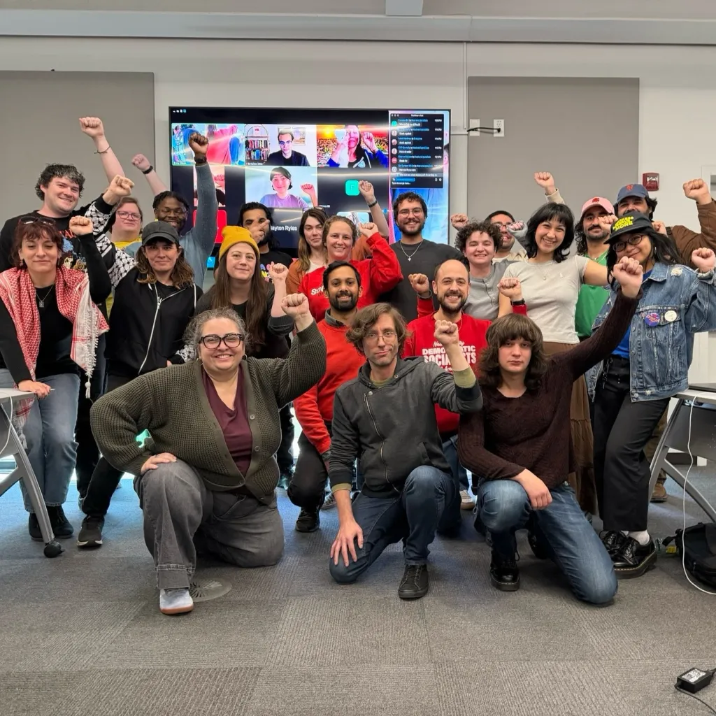 David Jenkins at a DSA meeting with a group of people raising their fists.