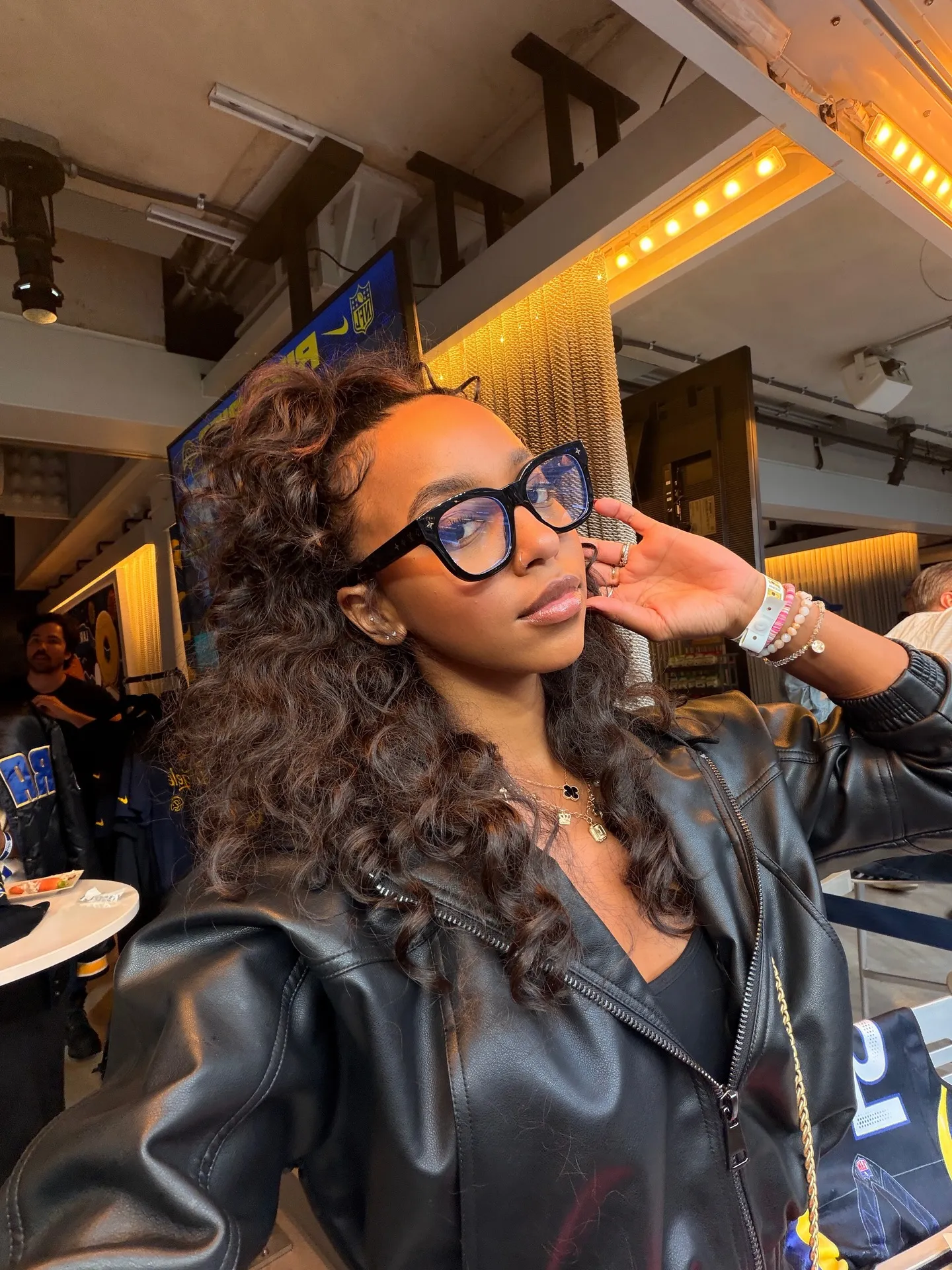 WNBA star Lexie Brown taking a selfie, wearing glasses and a black leather jacket.