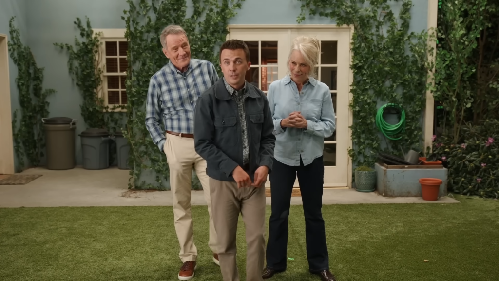 Malcolm, Lois, and Hal standing in a yard.