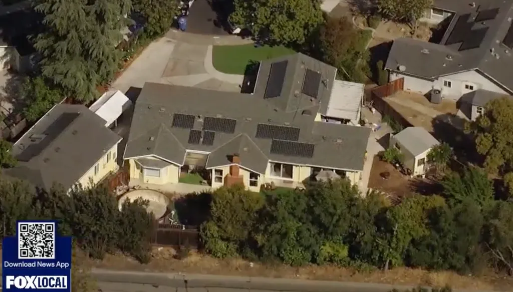 Aerial view of a house with solar panels on its roof.