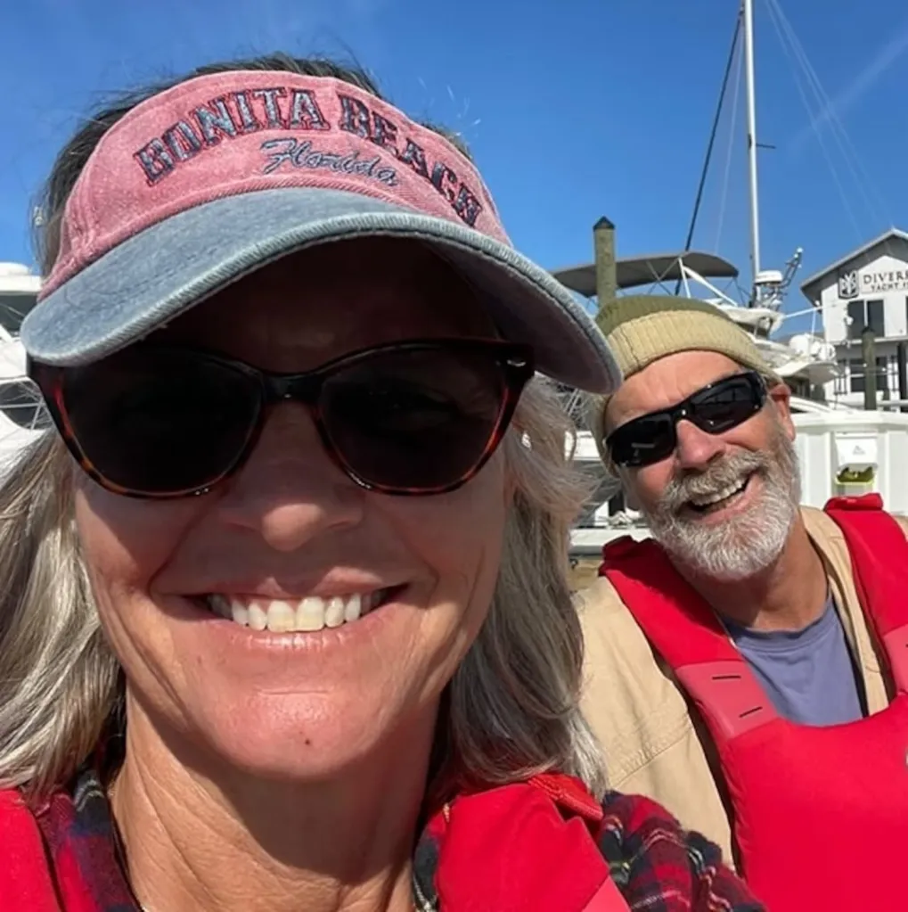 Lynette Hooker and her husband Brian smiling on a boat.