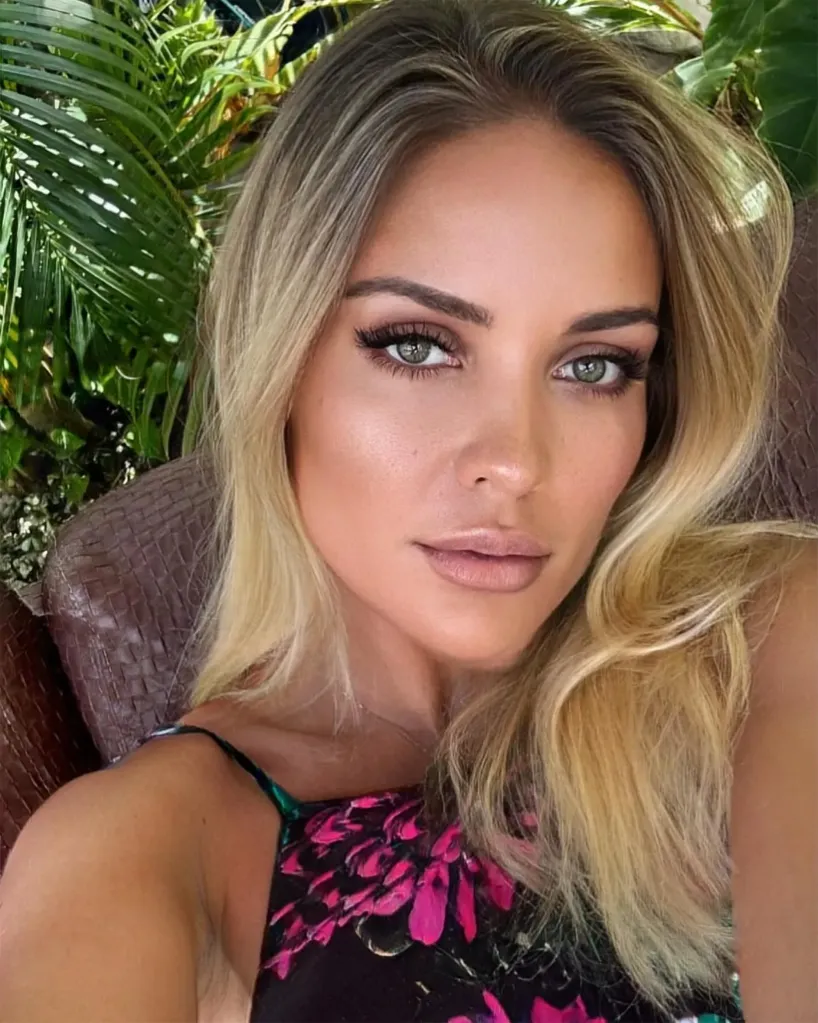 A woman with long blonde hair and green eyes looks directly at the camera.