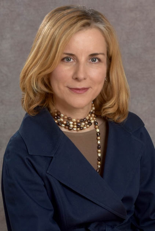 Maria Karayiorgou, MD, Professor Emerita of Psychiatry at Columbia University Medical Center, wearing a dark blue coat and a pearl necklace.