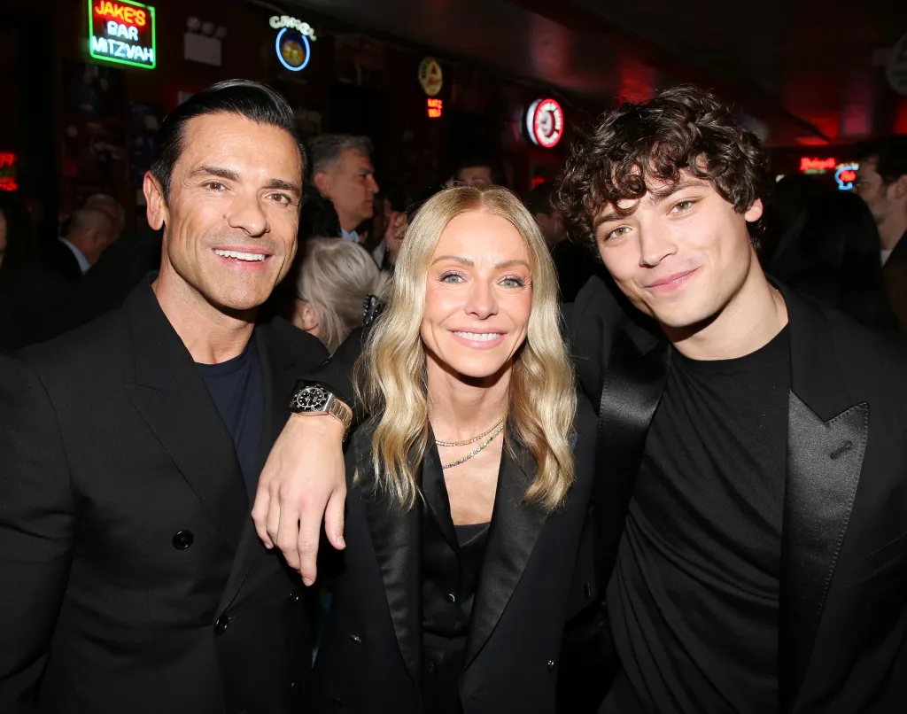 Mark Consuelos, Kelly Ripa, and Joaquin Consuelos smiling at the opening night after-party for a Broadway show.