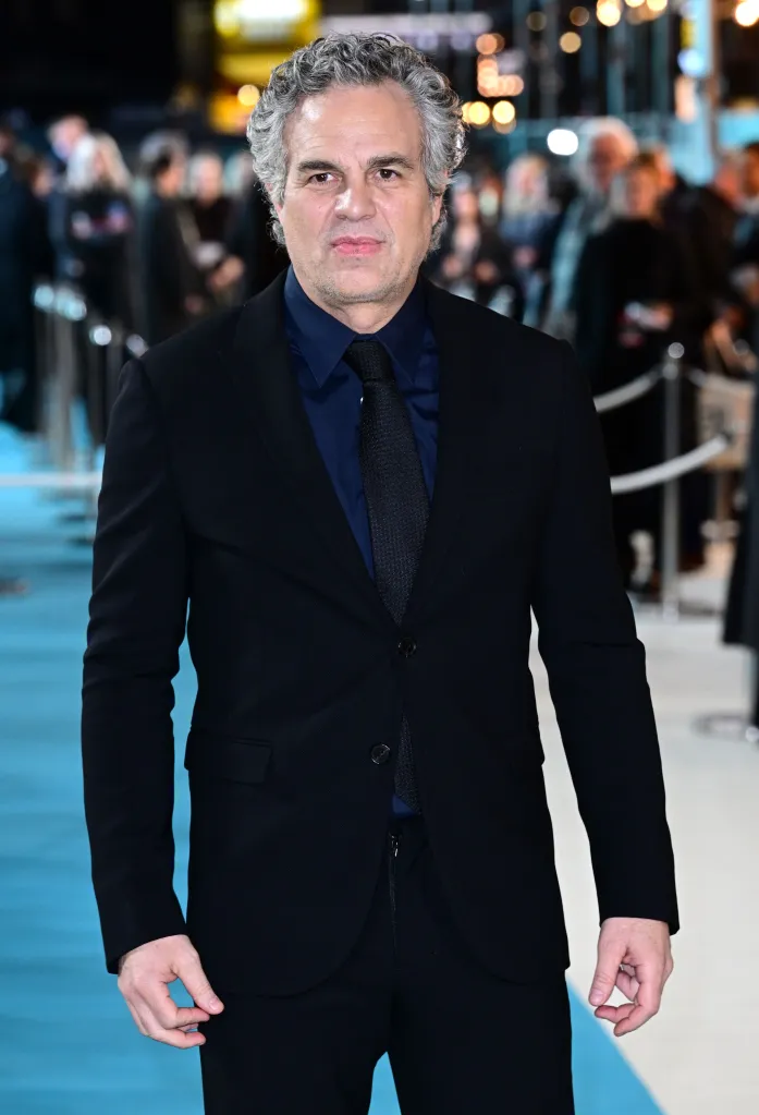 Mark Ruffalo in a black suit and navy shirt with a black tie.