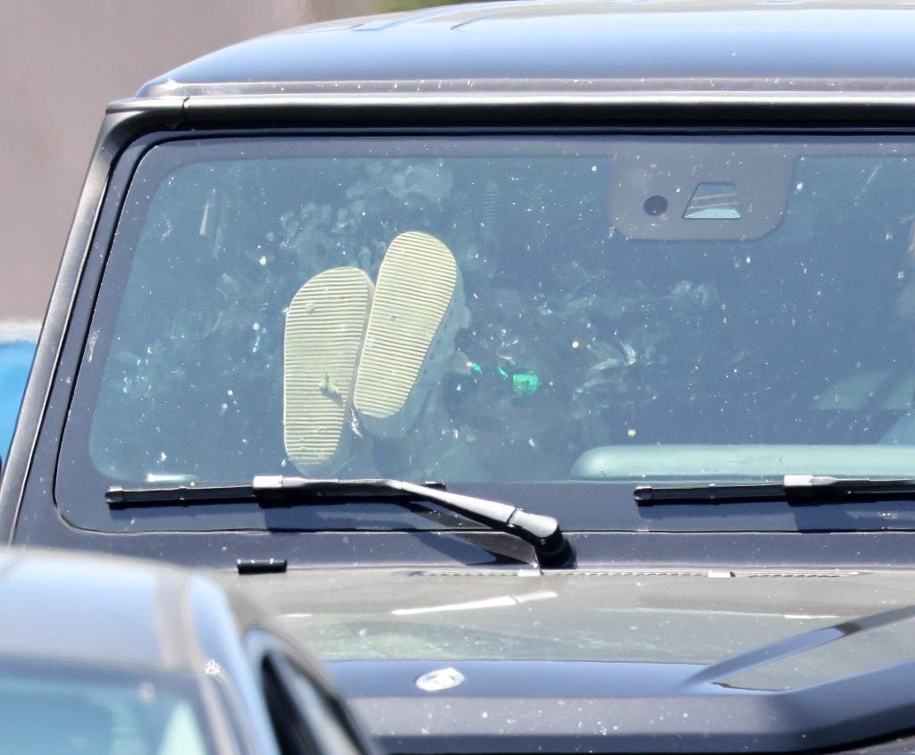 Britney Spears' feet, in sandals, resting on the dashboard of her Mercedes G-Wagon.