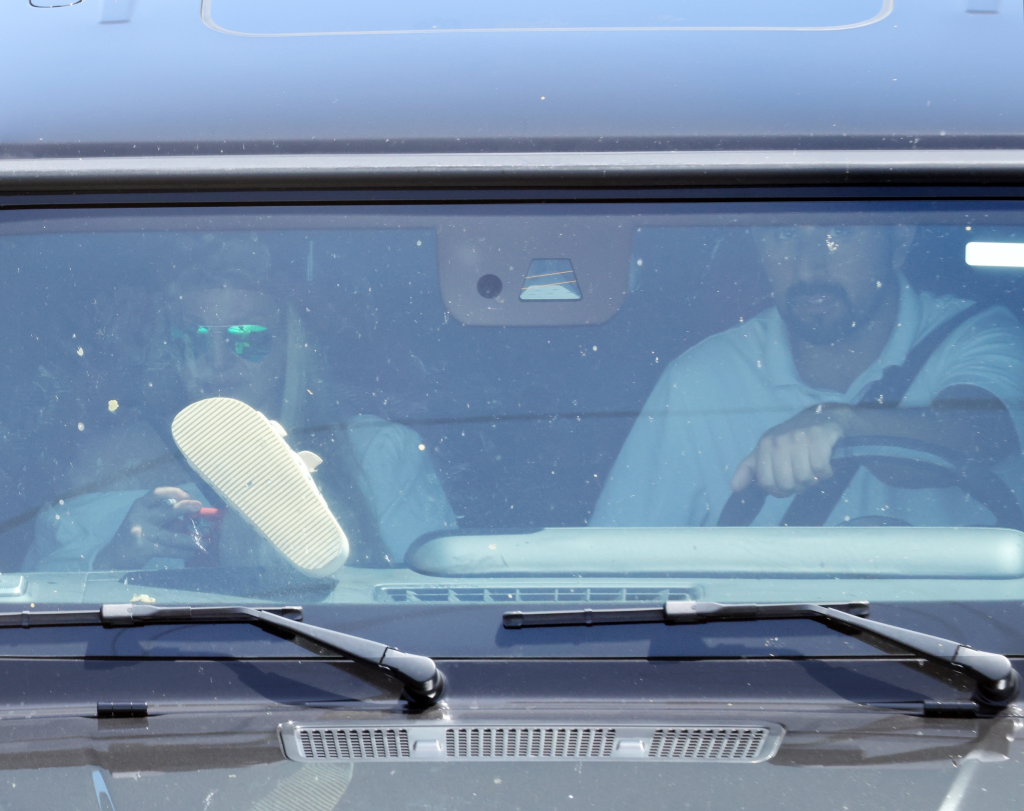 Britney Spears smoking a cigarette with her feet on the dashboard of a Mercedes G-Wagon.