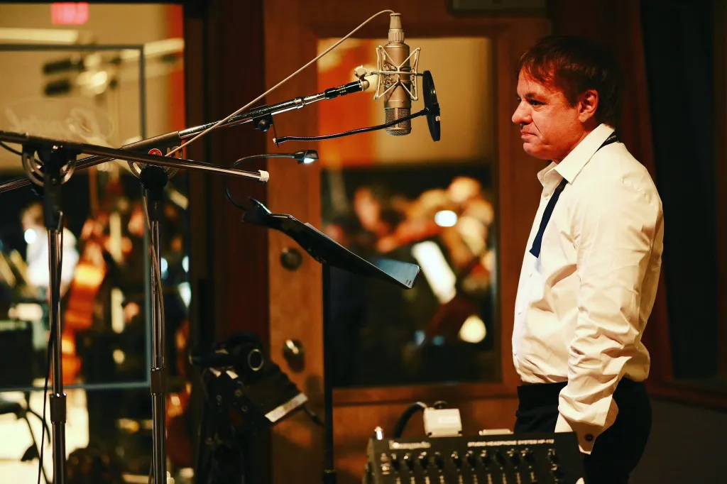 Maximilien de Hoop Cartier standing by a microphone in a recording studio.